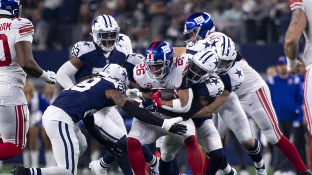 Nov 24, 2022; Arlington, Texas, USA; New York Giants running back Saquon Barkley (26) is tackled by the Dallas Cowboys defense during the second half of the game between the Cowboys and the Giants at AT&T Stadium.